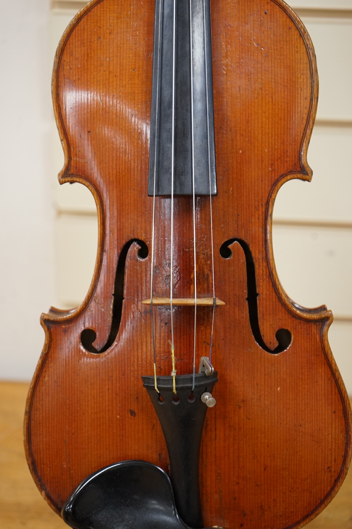 Three cased violins; a German Dresden violin, supplied by Campbell and co., Glasgow, together with another Dresden Stradivarius copy, and the remains of a European violin.